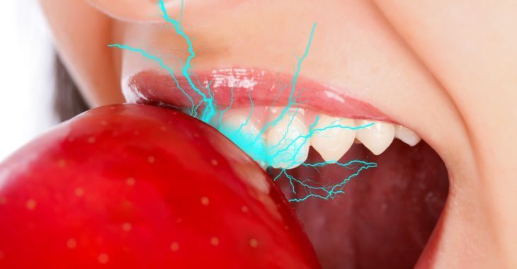 Woman feeling toothache when biting an apple
