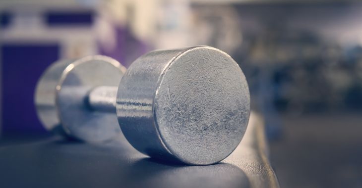 Sports weights on a bench in a gym.