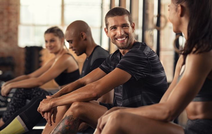 A group of athletes exercising on a rowing machines at a gym