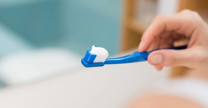 A person holding a toothbrush with toothpaste 