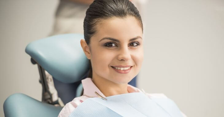 a satisfied woman at post-wisdom tooth extraction checkup sitting relaxed in a dental chair