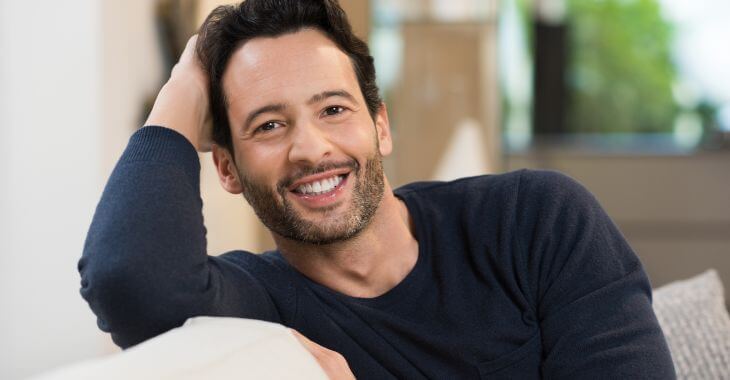 cheerful smiling young man relaxing on a sofa at home