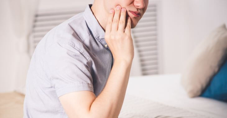 A man with dental pain caused by wisdom tooth 