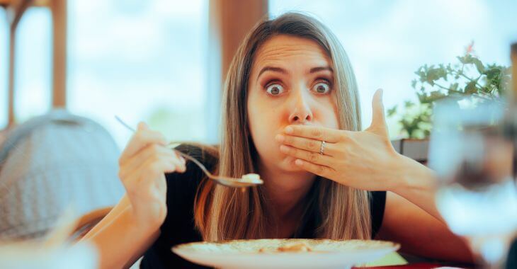 A woman feeling tooth pain while eating